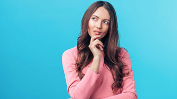 woman in pink dress thinking against blue background, hero banner for Zenana vs BiBi article on The Donjane Edit blog          Ask ChatGPT