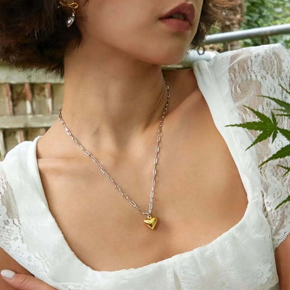 stainless steel heart pendant necklace shown as women’s activewear