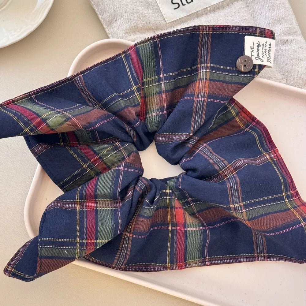 Navy tartan plaid hair scrunchy with red and green checks, laid flat showing full oversized bow shape and label detail