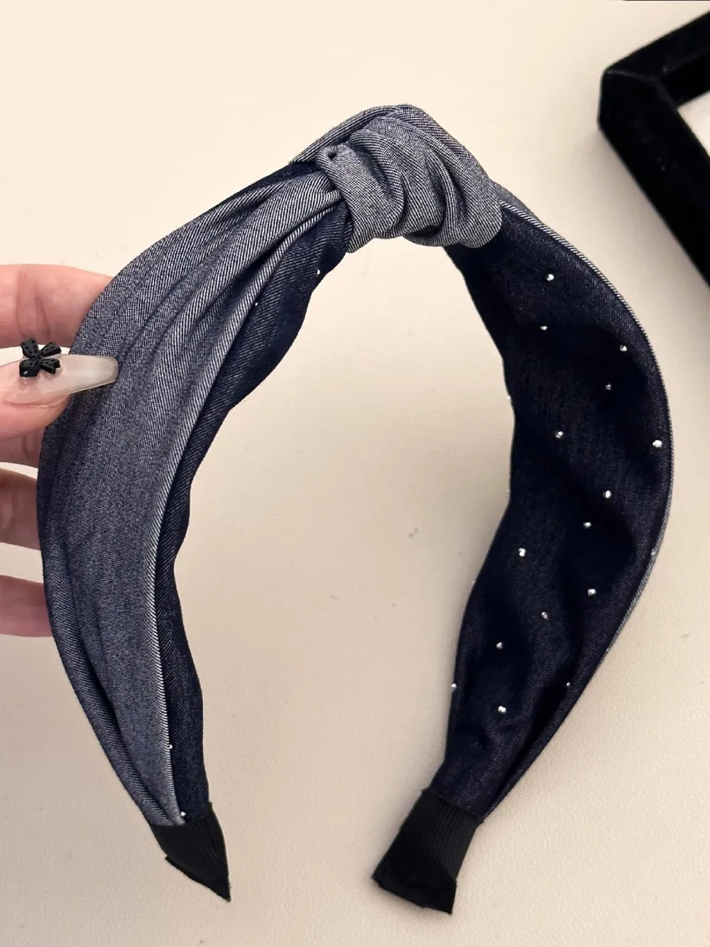 black headband with silver studs and center knot design
