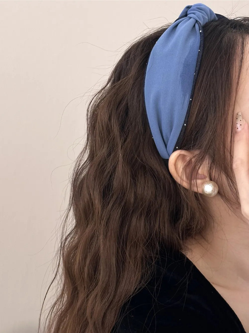 woman wearing light blue knotted headband with wavy hair