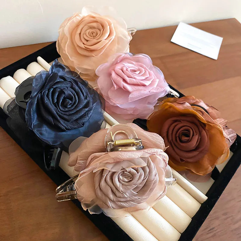 blush pink, navy, and beige acrylic flower hair clips on display tray

