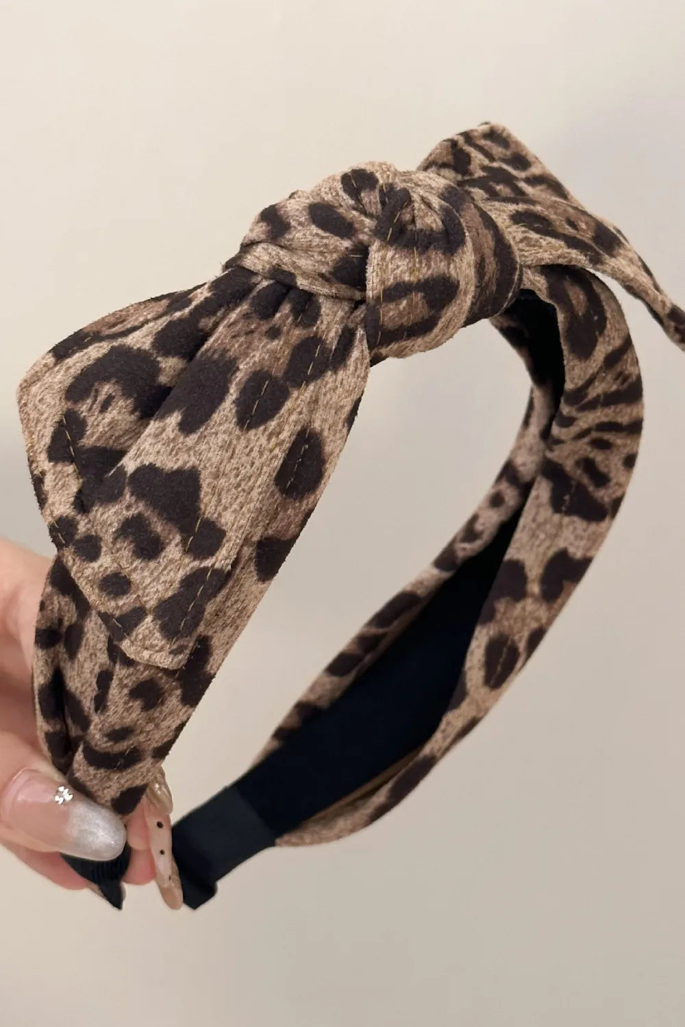 side view of twisted leopard headband styled on dark wavy hair