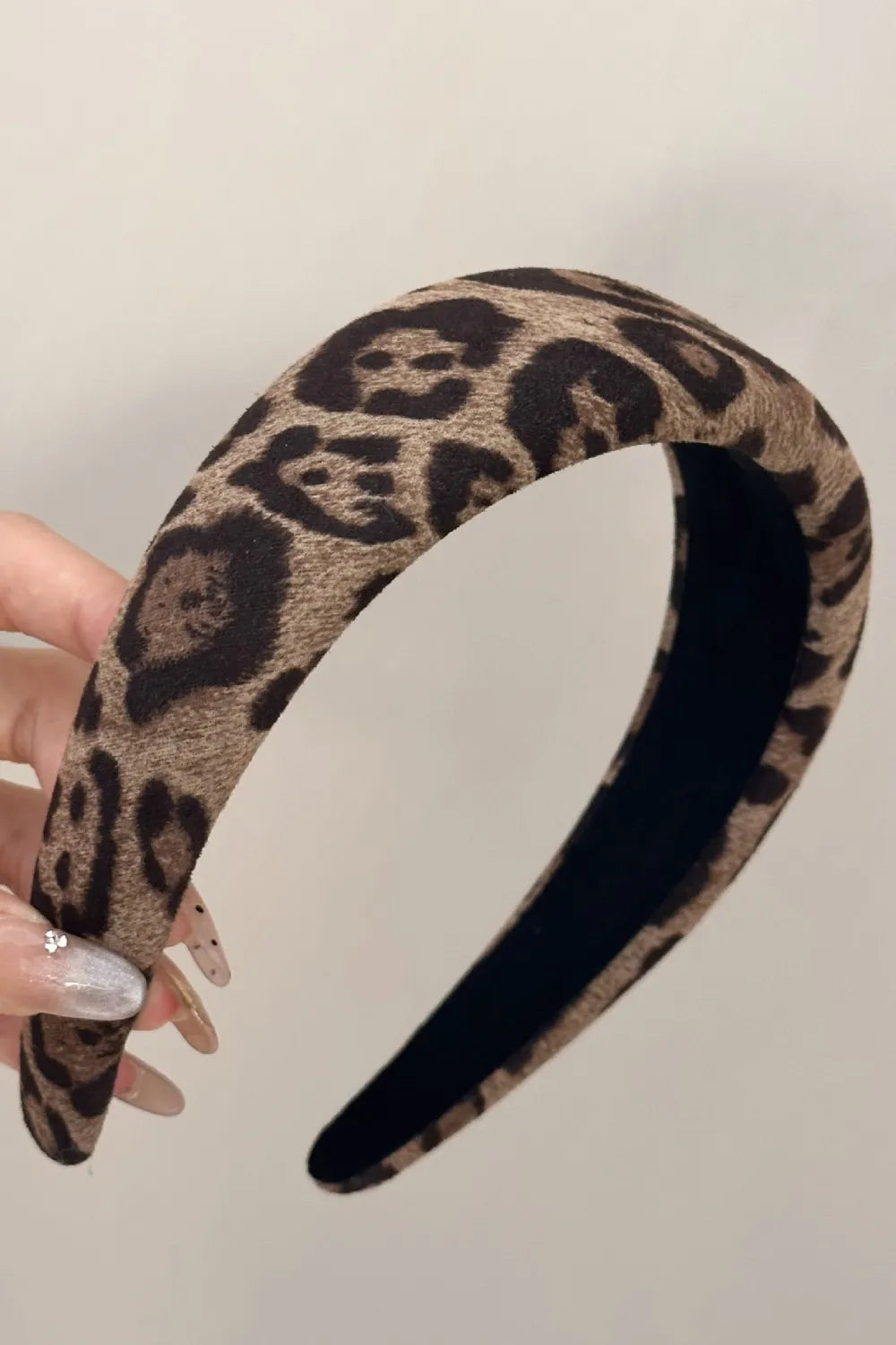 close-up of leopard print wide headband held in hand