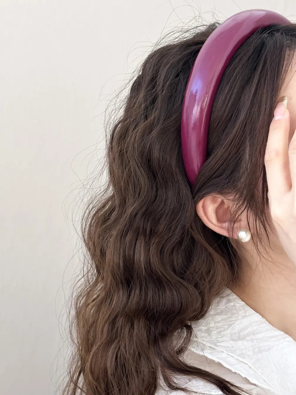 deep red glossy PU headband with soft lining shown in hand